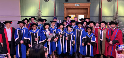 A group of PhD student and staff celebrating in the Octagon after the graduation ceremony