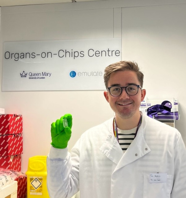 Dr Timothy Hopkins holding an organ-chip in the lab