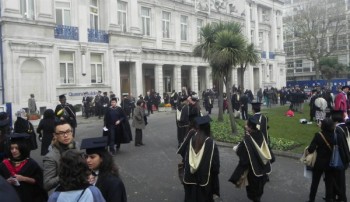 Students braved the cold by gathering outside the Queen's Building with their friends and family.