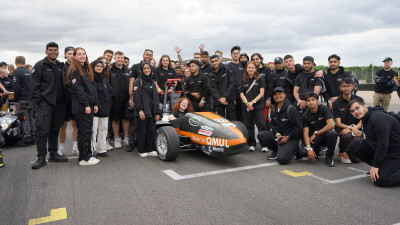 The Formula Student Team at Silverstone with Team Principal, Cara Fox seated in the car.