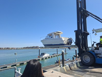 Our engineering students watching a boat being lifted from the water at the shipyard.