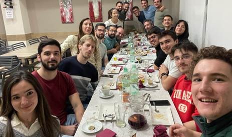 A large group of friends take a selfie at dinner