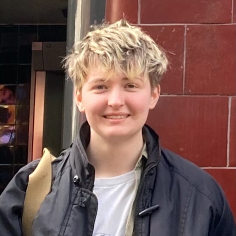 Lewis Corry in front of a red brick wall