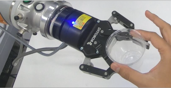 Robot passing flexible cup to human