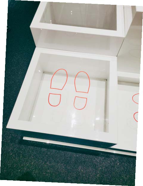 A white and glass box with shoe prints
