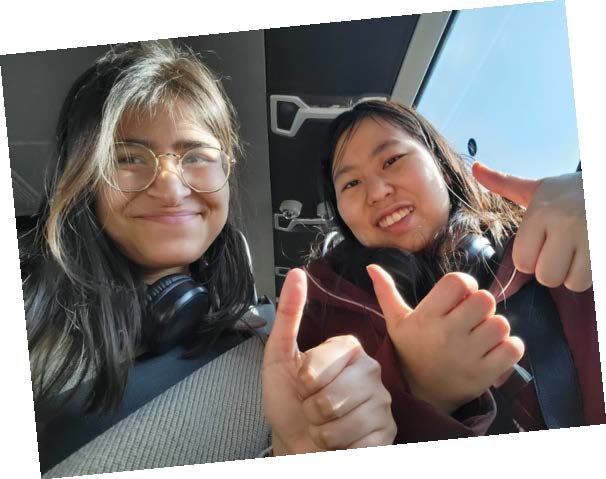 Two students giving thumbs-up on a coach